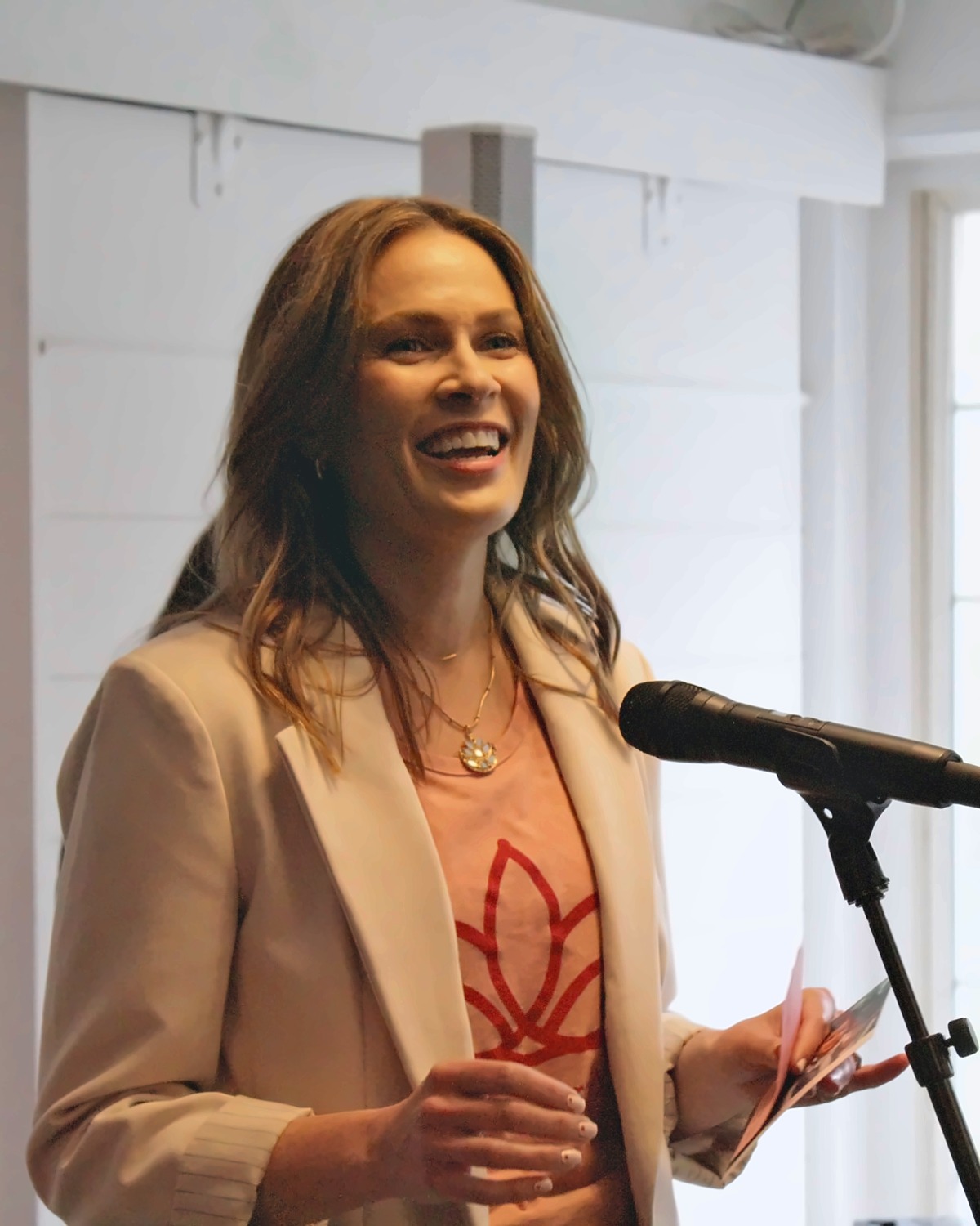Heather Aho smiling while speaking at a microphone